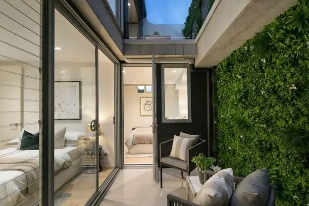 Modern interior with glass doors leading to a patio with greenery