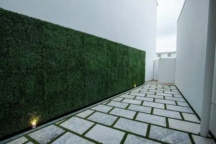 Modern outdoor patio with artificial green wall and stone pavement
