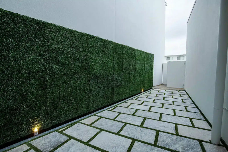 Artificial boxwood panels along a side wall
