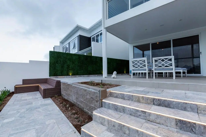 Modern house exterior with outdoor seating area and steps leading up to the entrance.