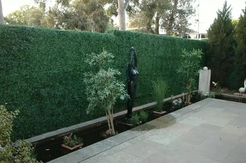 Before – This courtyard previously had a number of artificial plants and a plain render wall.