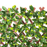 Artificial green leaves on a wooden trellis against a white background