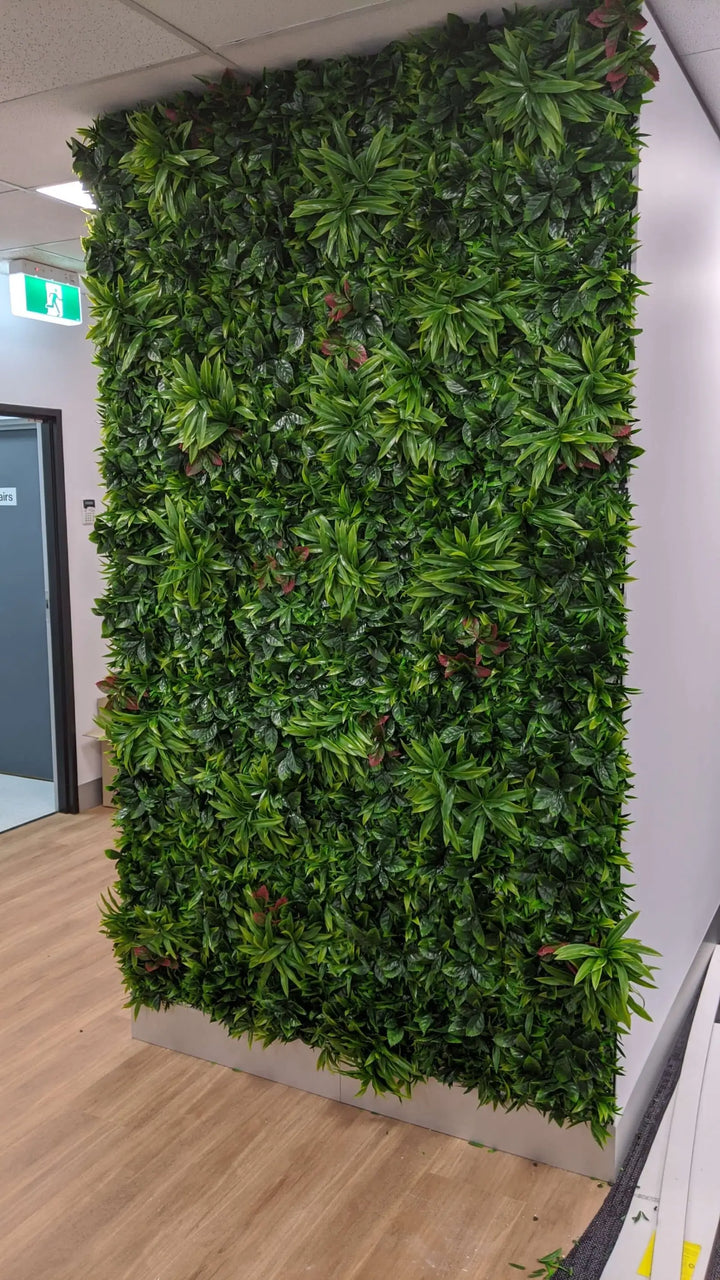 Green artificial plant wall in an indoor setting