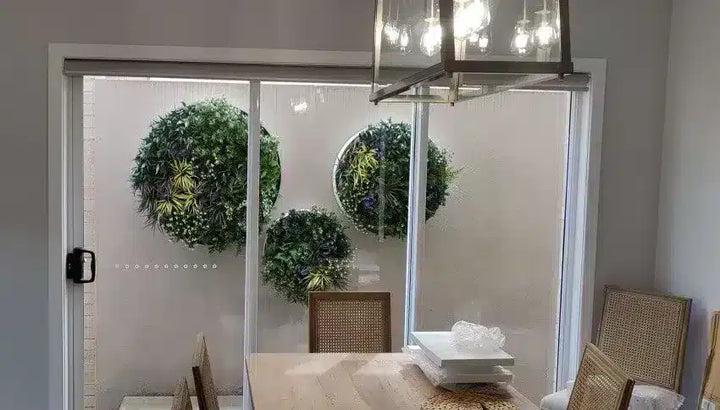 Dining room with sliding glass door, chairs, and decorative wreaths.