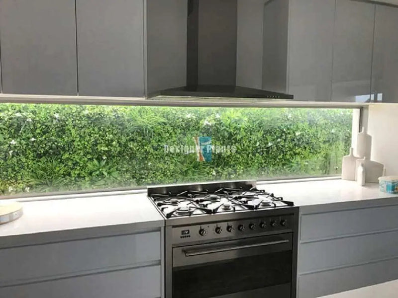 Kitchen window glass splash back with a green wall