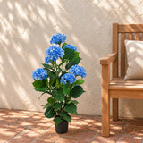 Blue artificial hydrangea in its black pot beside a courtyard bench.