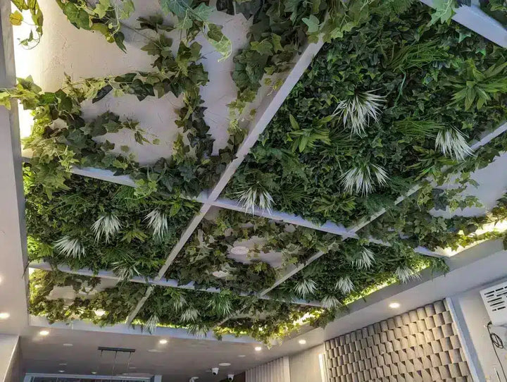Green artificial plants on a ceiling grid system