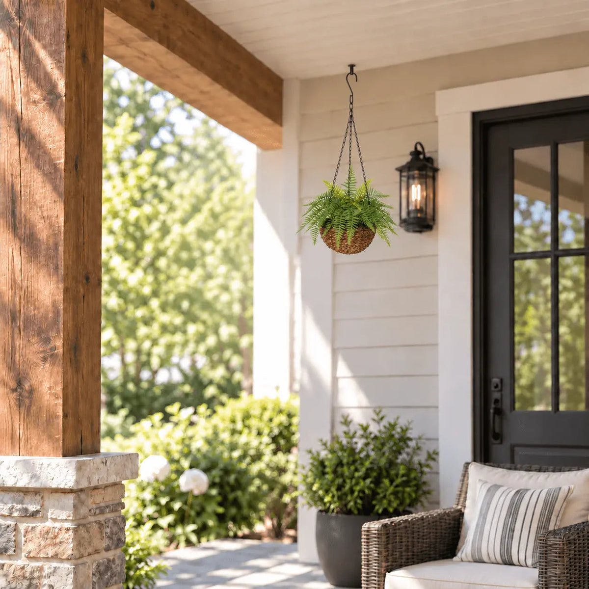 Medium UV-resistant artificial fern hanging basket shown outdoors on a covered porch at realistic scale