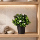 20cm artificial flowering boxwood in its supplied black pot on a bathroom shelf; towels and fittings shown for styling.