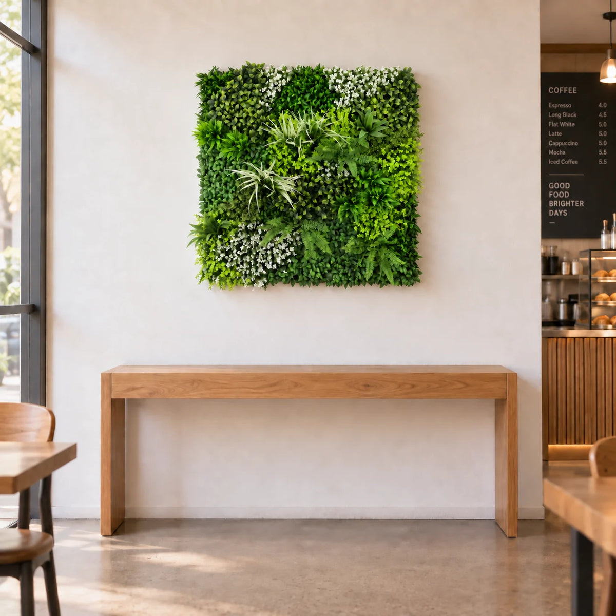 Forest Floor 1m x 1m artificial green wall panel styled above an oak console in a cafe. Furniture is not included.