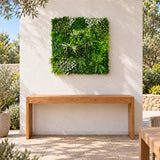1m square Forest Floor artificial green wall panel above a timber console in an outdoor courtyard.