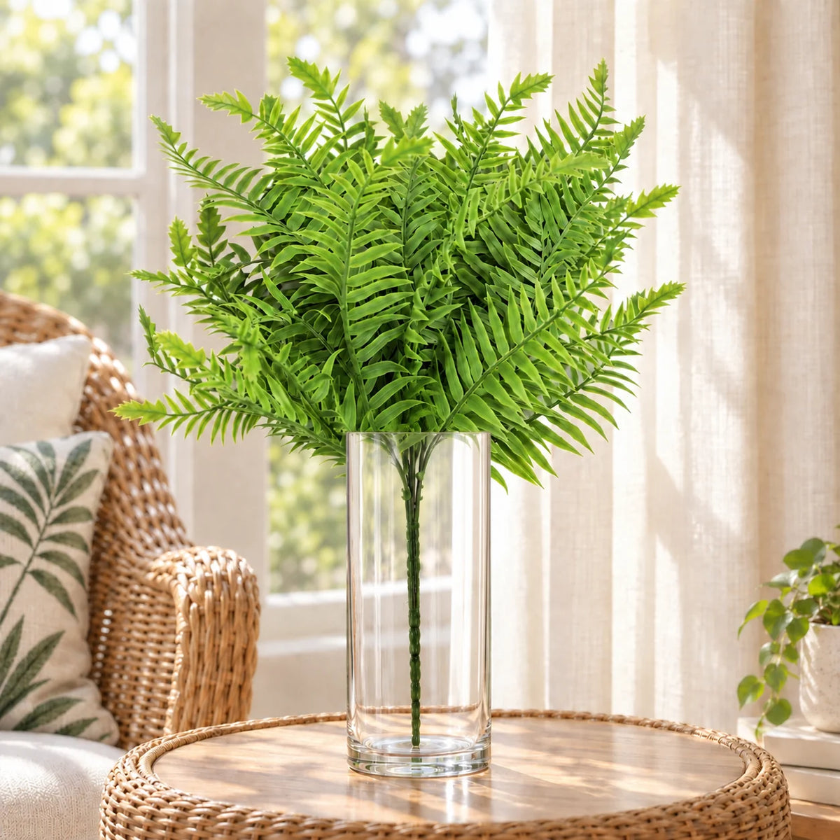 Artificial lady fern stem in a clear vase on a sunroom side table.