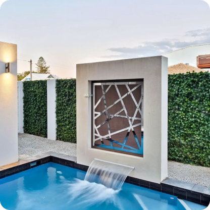 modern pool area with geometric water feature and green accents