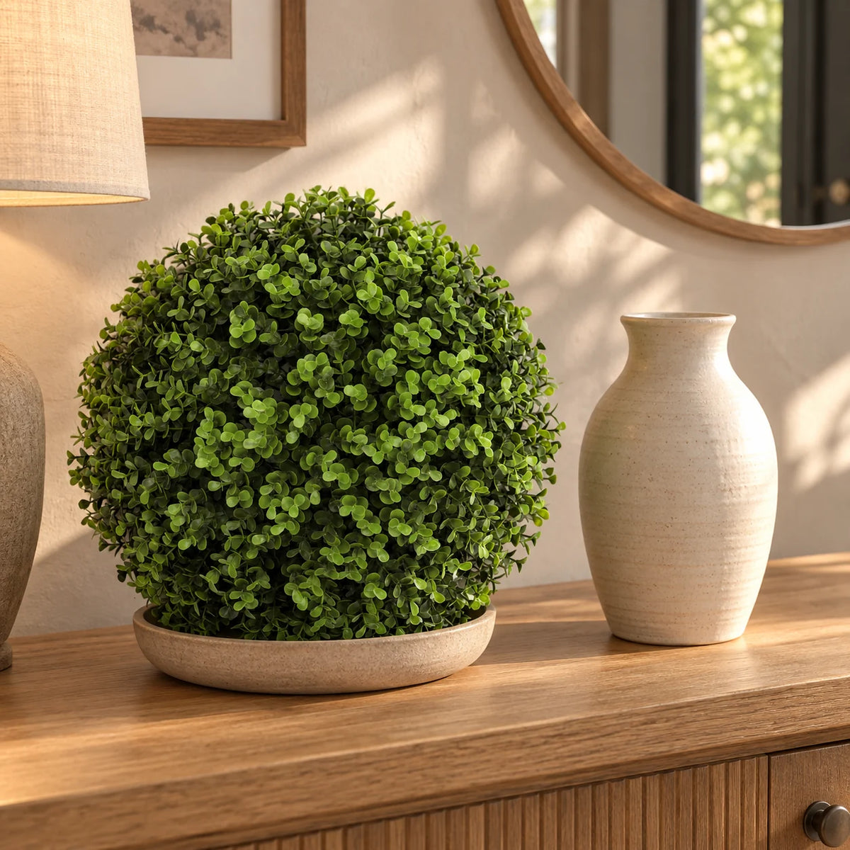 28cm natural-tone artificial Buxus ball on a console beside a ceramic vase.