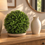 28cm natural-tone artificial Buxus ball on a console beside a ceramic vase.