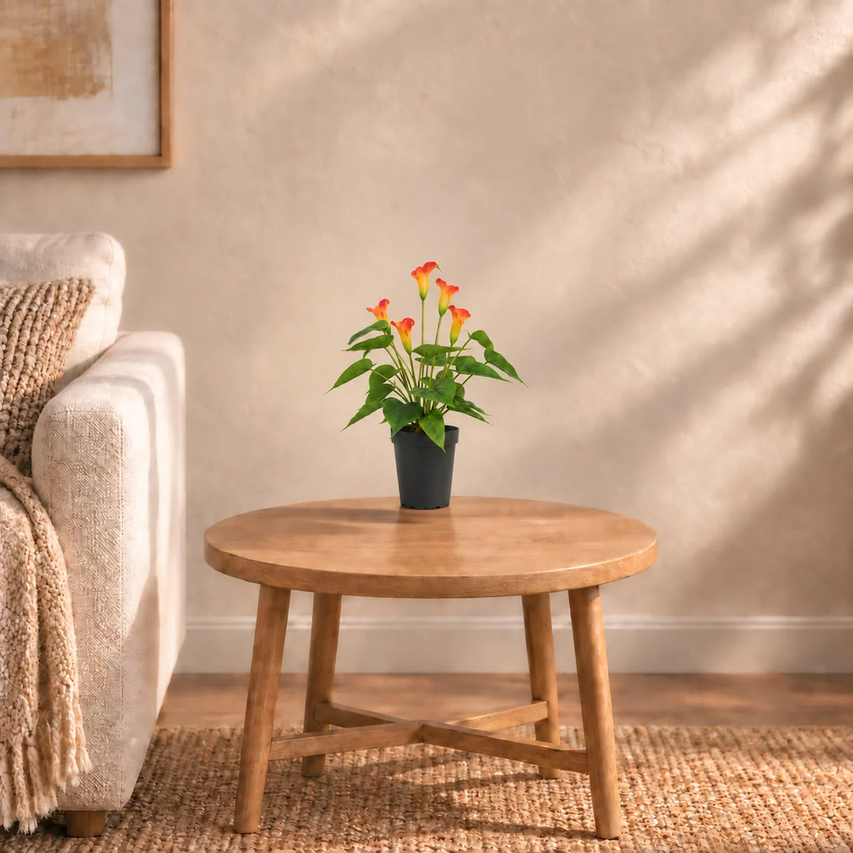 50cm artificial orange calla lily in its supplied black pot on a living-room side table; furniture shown for styling.
