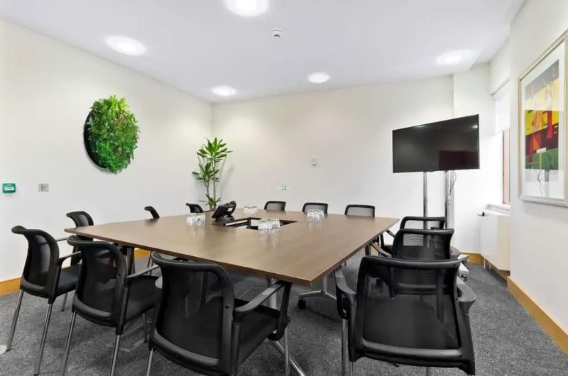 Office meeting area with furniture after artificial green wall installation