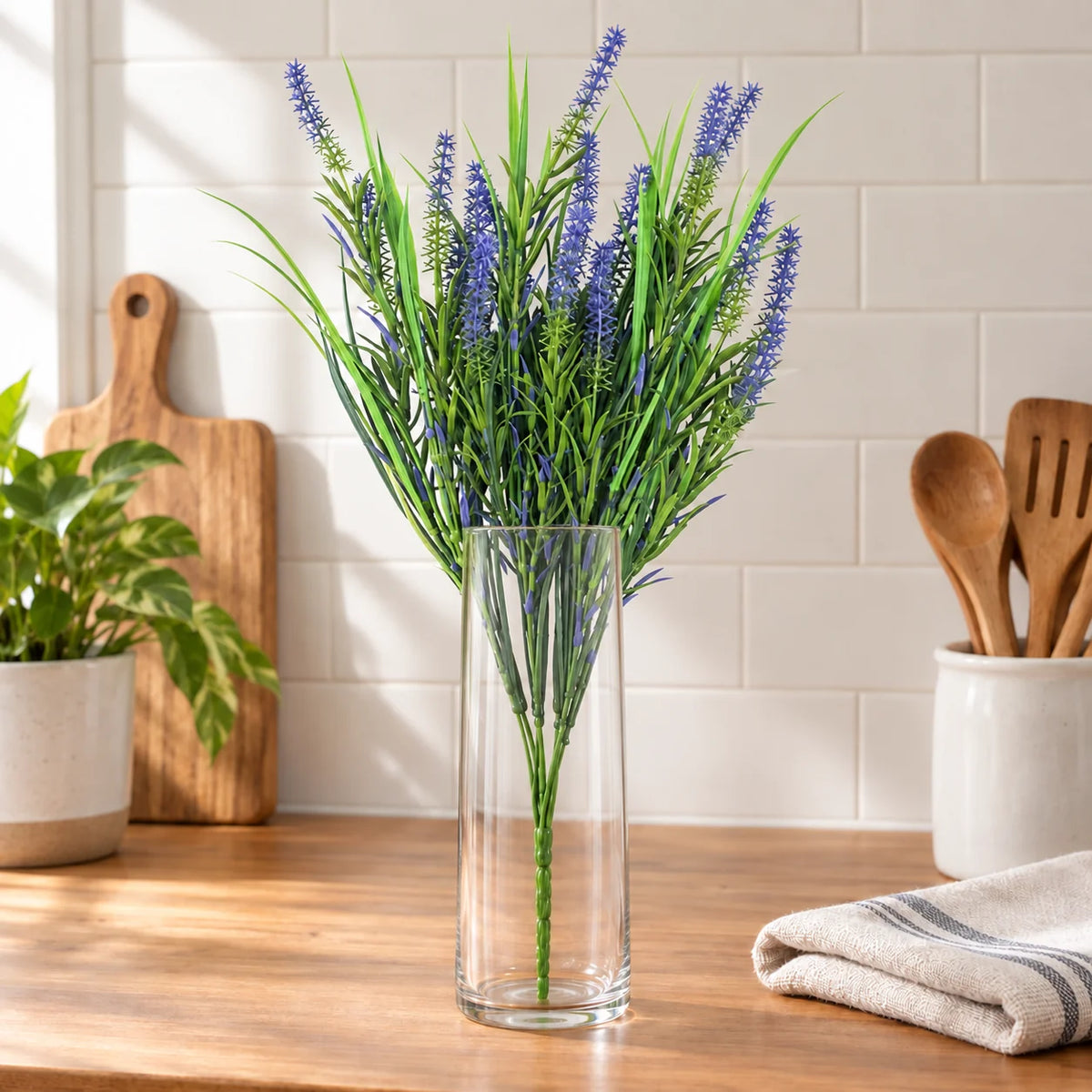 50cm artificial purple lavender stem in a clear vase on a kitchen bench.