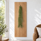 Artificial Spanish moss suspended from a small hook against a timber sunroom panel.