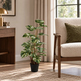 35.4-inch variegated Monstera Deliciosa artificial tree in its black nursery pot beside an indoor lounge chair