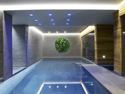 Indoor pool area with modern decor and ceiling lights.
