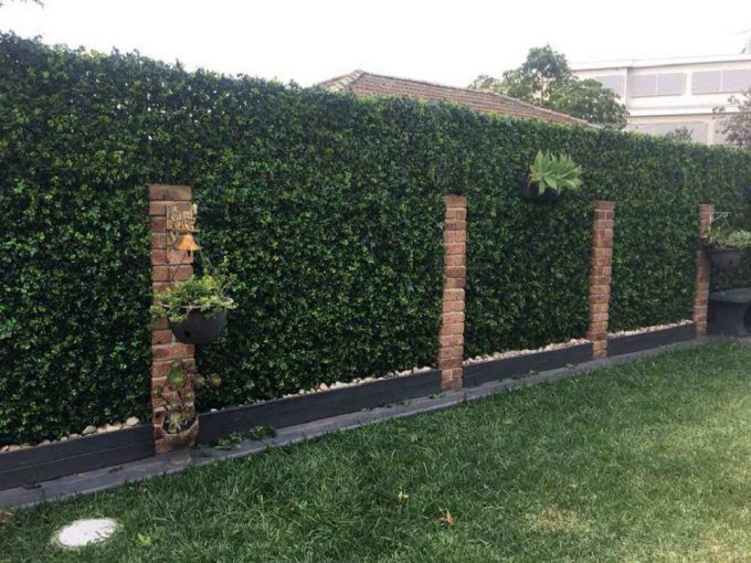 Artificial spring sensation hedge on a backyard fence for privacy