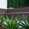 Artificial boxwood panels along an outdoor bench