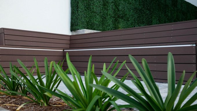 Artificial boxwood panels along an outdoor bench