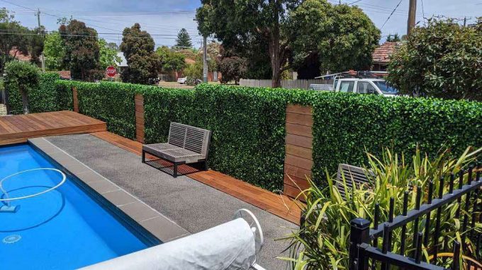 Artificial-jasmine-hedge-tiles-around-a-pool-area