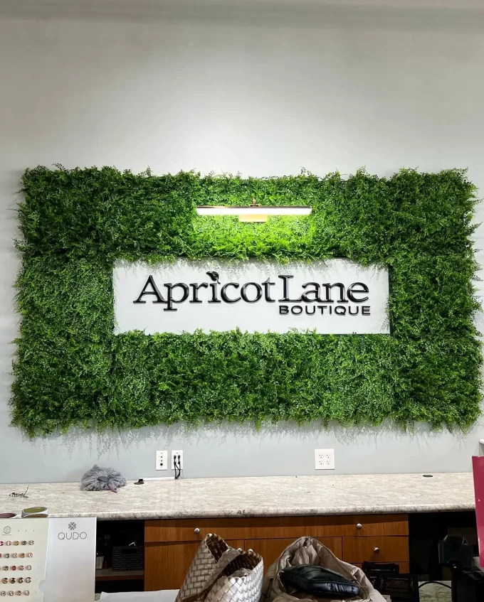 Natural looking Mediterranean Fern panel with a company logo