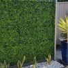 fake boxwood hedge panels on a wall