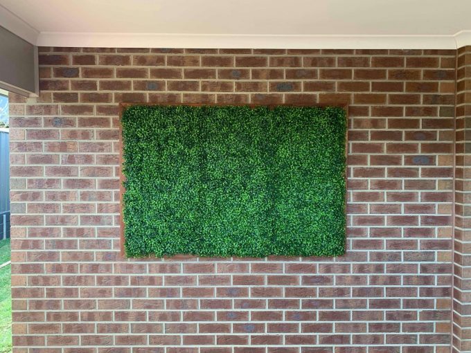 fake hedge panels installed onto brick