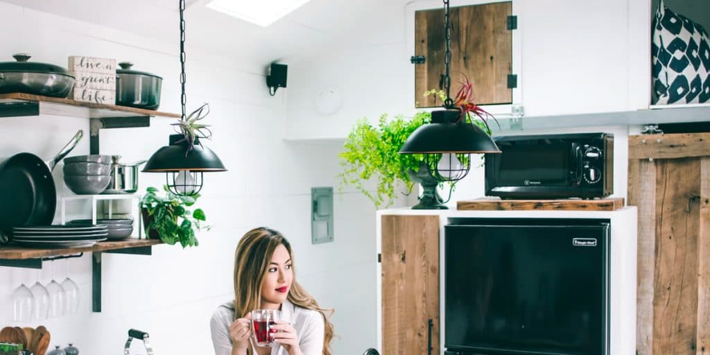 A lady holding a cup of red tea trying to get warm in the home