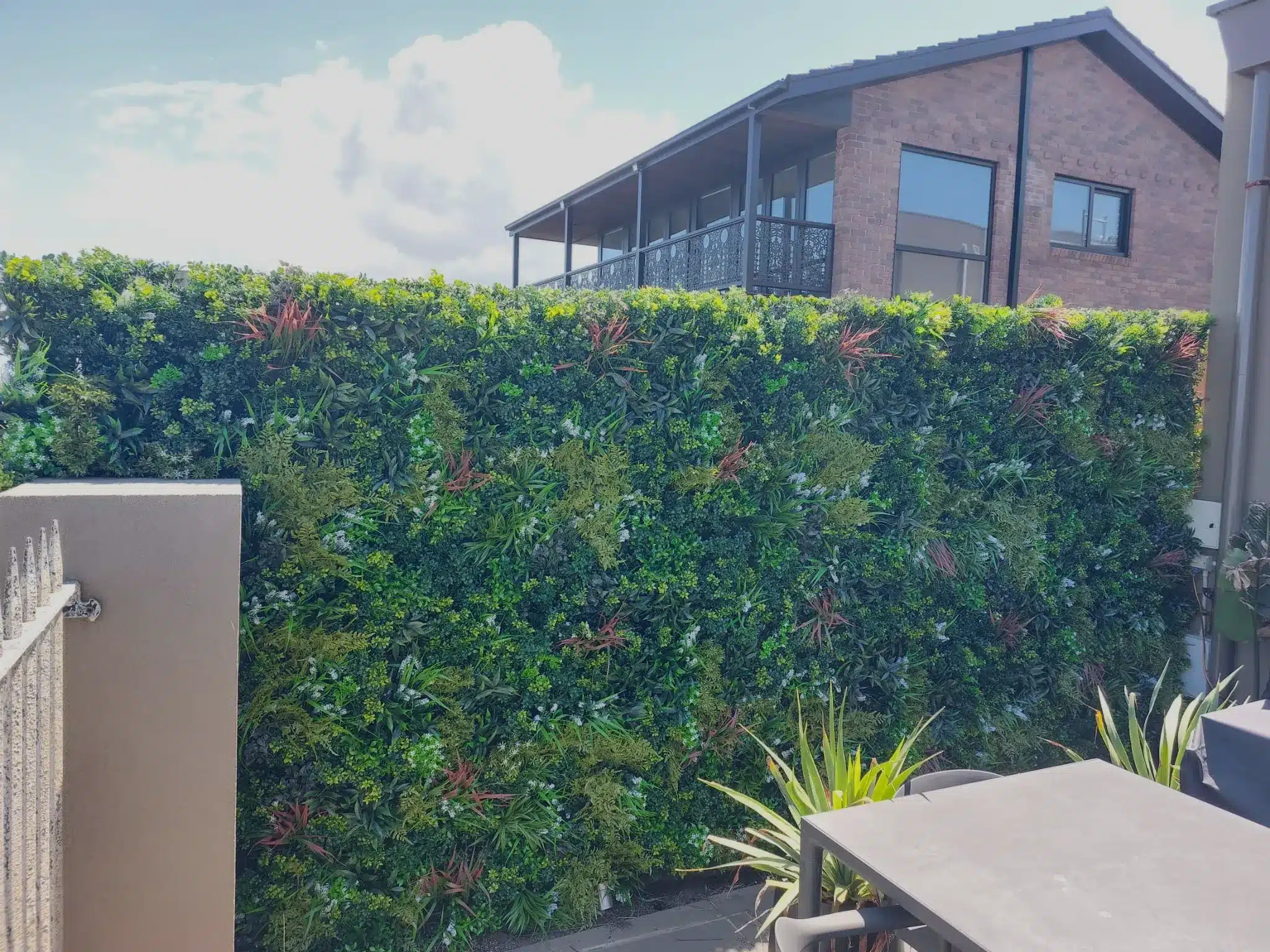 Beach home with an outdoor vertical garden wall installed with dense plant coverage