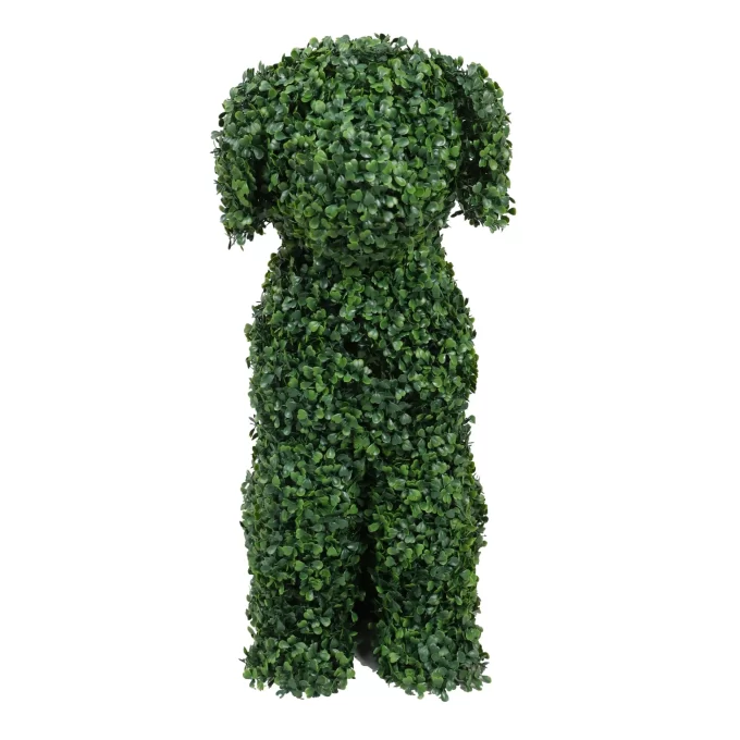 Green leafy topiary dog sculpture sitting in a garden. A stunning piece of garden art with intricate foliage, adding charm to any outdoor space