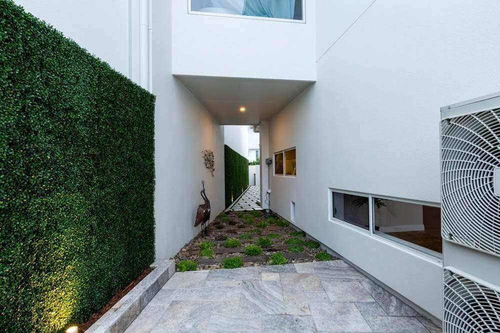 Artificial boxwood panels along a side wall