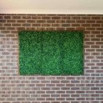 fake hedge panels installed onto brick