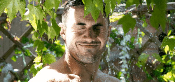 A Man is Soaked by Falling Water on Leaves in His Garden For World Naked Gardening Day