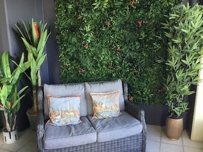 Artificial green walls are perfect for small spaces like this balcony