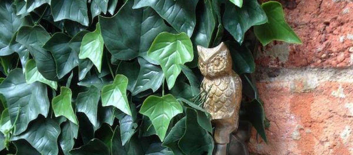 FEATURED - Fake ivy on a brick wall with an small owl sculpture